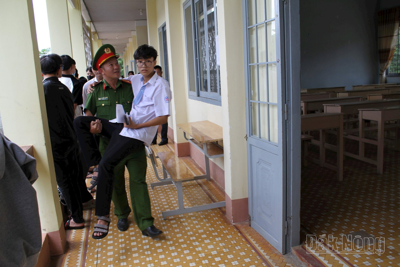 Thí sinh Phạm Ân được chiến sĩ Công an hỗ trợ đưa vào phòng thi. Ảnh: Báo Đắk Nông