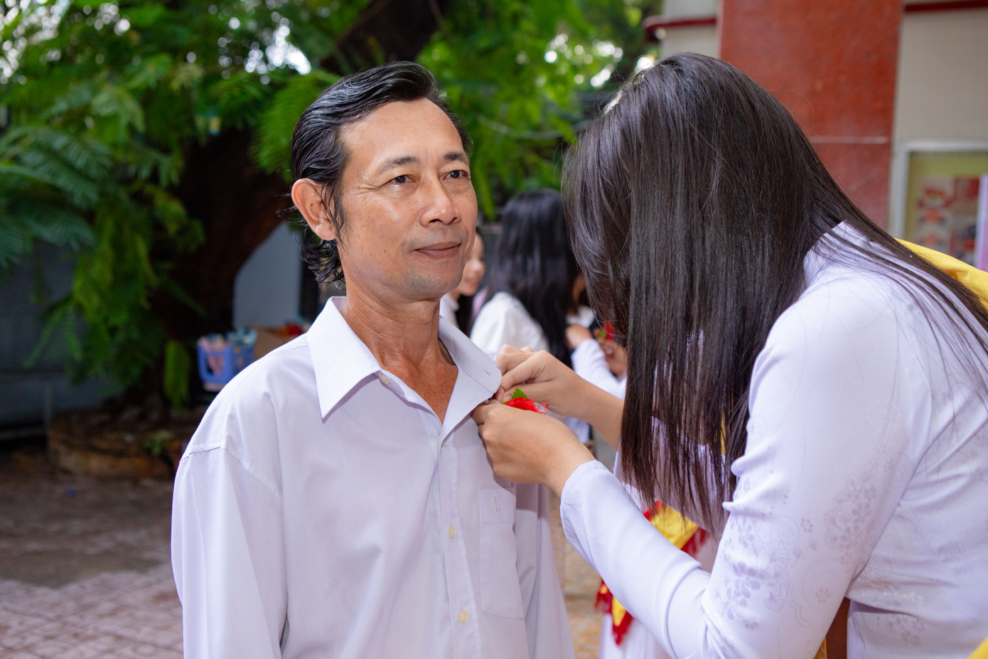 Học sinh bày tỏ lòng biết ơn đến quý phụ huynh qua hoạt động cài hoa lên áo.