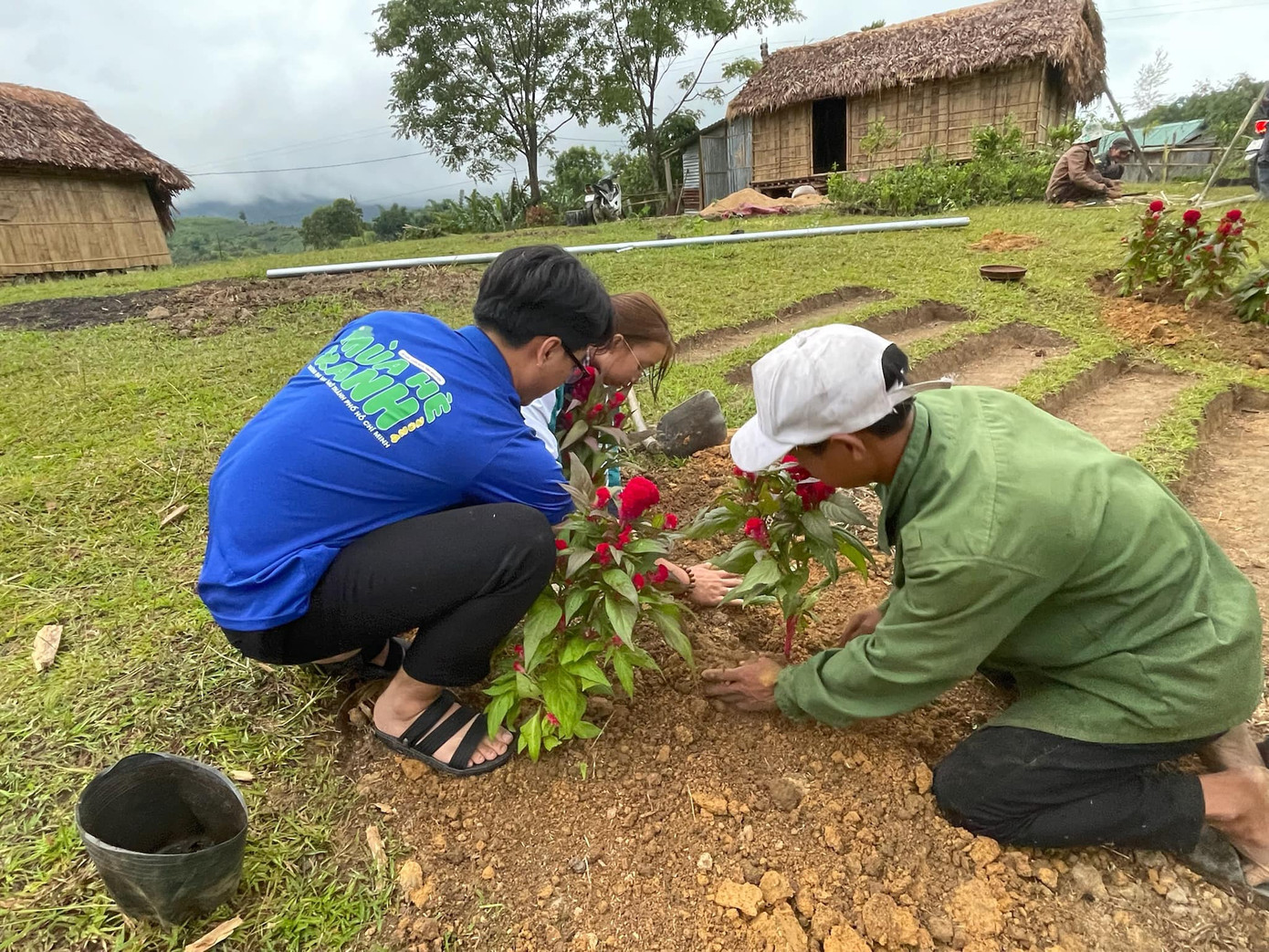 Cùng ngày, các chiến sĩ đã sớm làm quen và cùng với người dân địa phương thực hiện trồng hoa tại khuôn viên tại công trình nhà dệt thổ cẩm. Ảnh: Đội hình Kon Tum - Mùa Hè Xanh OU 2024