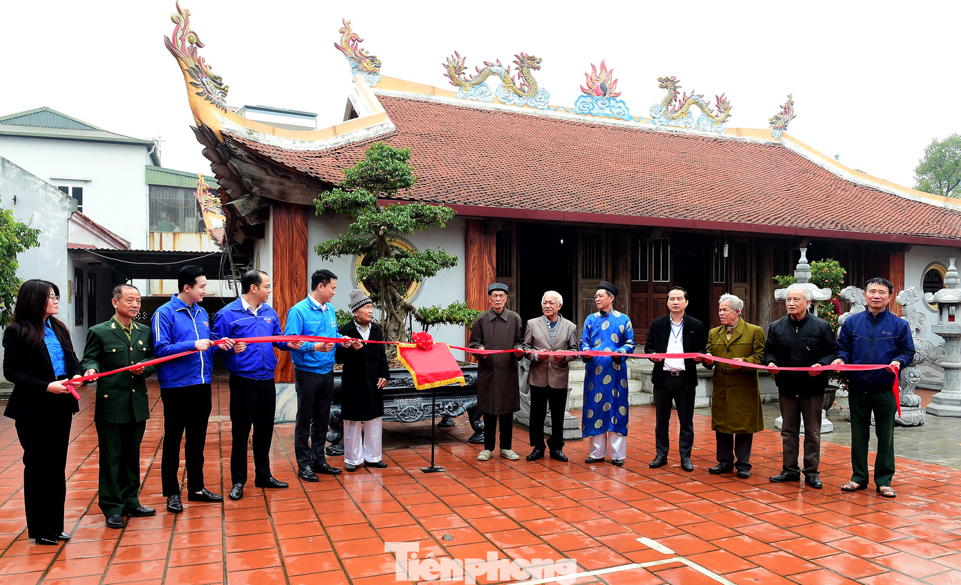 Các bậc cao niên cùng đại diện Đoàn Thanh niên thực hiện nghi thức khánh thành công trình bảng quét mã thông tin di tích đình Thượng Đồng. Ảnh: Xuân Tùng