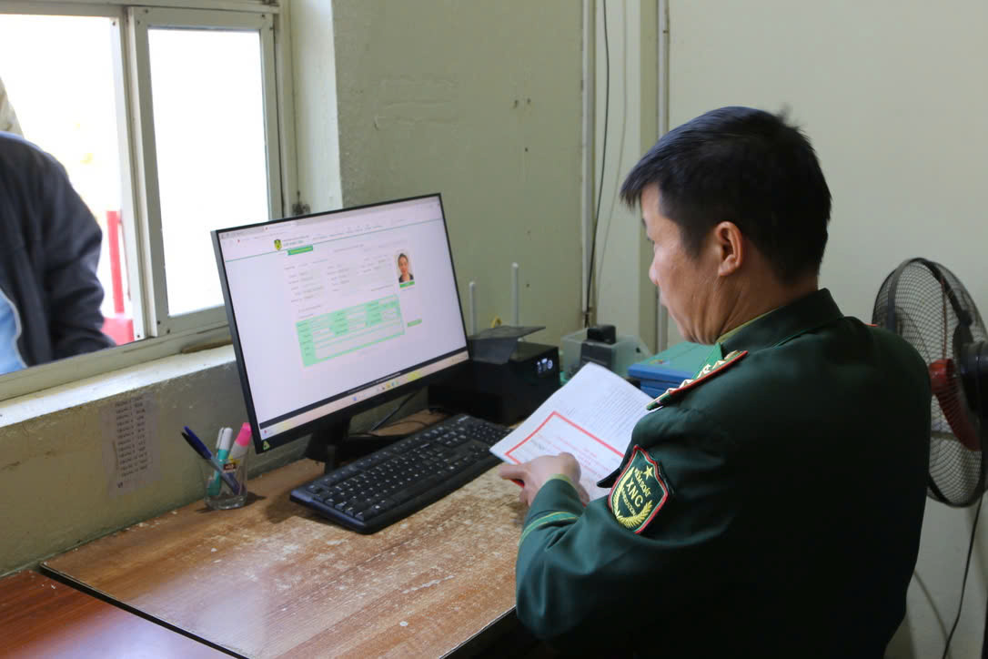 Cán bộ Trạm kiểm soát Biên phòng Cửa khẩu Tén Tằn làm thủ tục xuất cảnh cho công dân Lào.