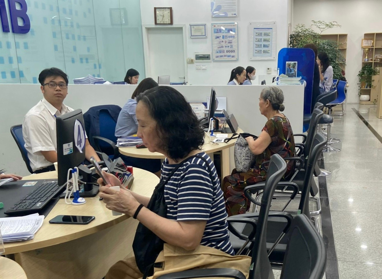 Người lớn tuổi tự cập nhật sinh trắc học với sự hướng dẫn của nhân viên ngân hàng. Người lớn tuổi tự cập nhật sinh trắc học với sự hướng dẫn của nhân viên ngân hàng.