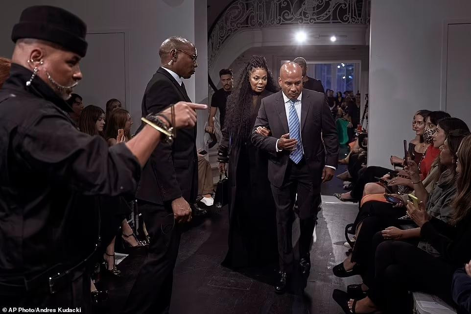 Janet được vệ sĩ hộ tống vào hội trường diễn ra show thời trang. Cô cũng được sắp xếp chỗ ngồi ở vị trí trung tâm, bên cạnh chủ nhân show diễn trong bữa tiệc chiêu đãi sau đó.