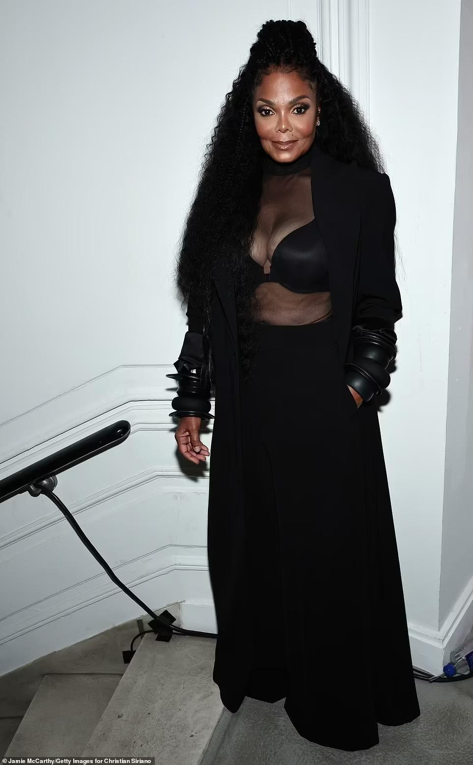 Điểm nhấn của bộ trang phục là chiếc áo cổ lọ xuyên thấu lộ nội y đen khoe vòng một "bốc lửa".