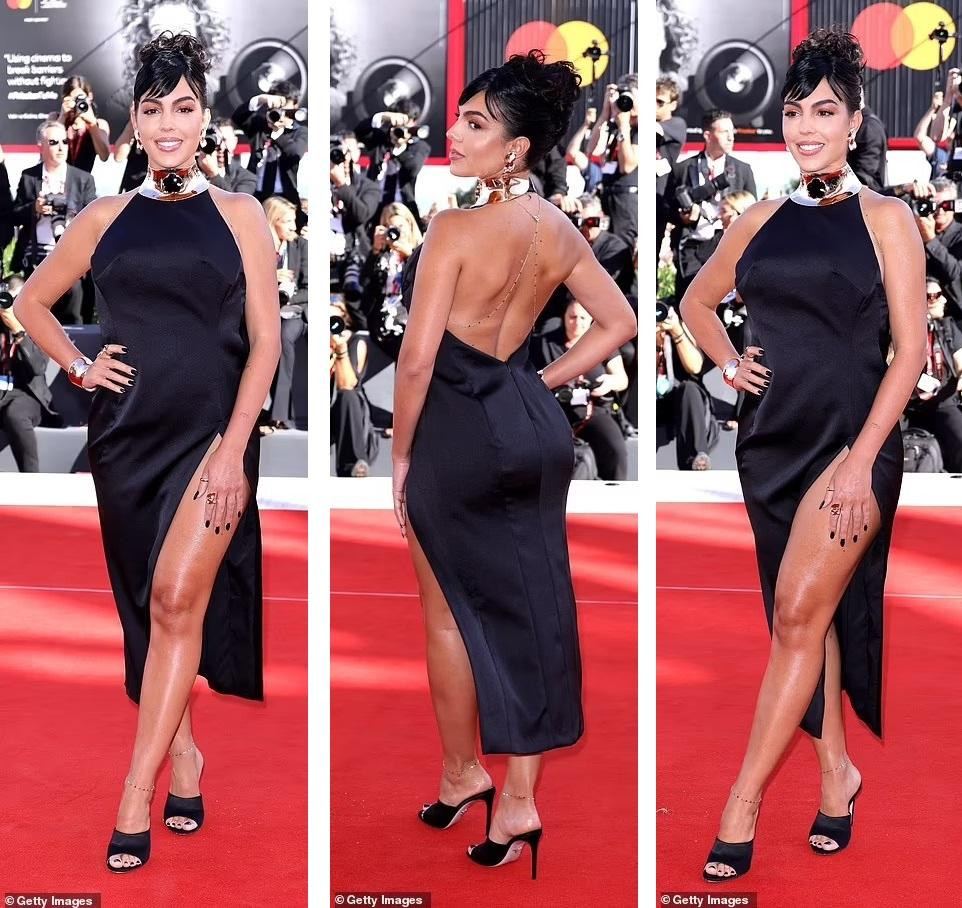 Bạn gái Ronaldo, Georgina Rodriguez, diện váy cổ yếm xẻ tà màu đen. Người đẹp 9x vẫn còn chút đẫy đà sau sinh nhưng điều đó không ảnh hưởng nhiều đến ngoại hình &quot;bốc lửa&quot; của cô.