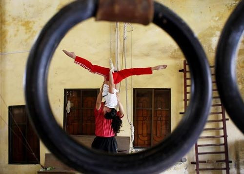 Thương tích trong quá trình tập luyện là chuyện hàng ngày. Khó khăn vất vả là thế, nhưng trên tất cả sự say mê yêu nghề đã khiến cho các học viên trẻ tuổi tại đây lại có một nghị lực phi thường đáng khâm phục. Trong ảnh: Khuất Thị Thùy Linh là học viên nữ nhỏ tuổi nhất tại đây. Em nhập học năm 11 tuổi và hiện nay đang là học viên năm thứ 3. Linh đang được thầy giáo hướng dẫn thực hiện động tác đu trên dây sao cho chuẩn xác và đẹp mắt nhất