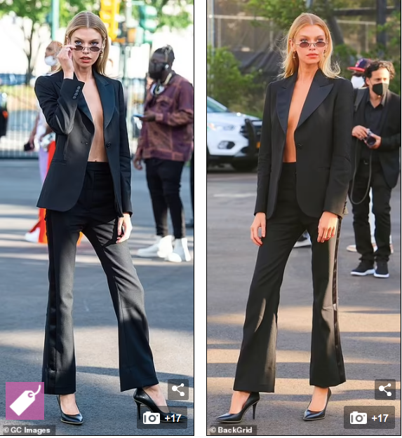 Stella Maxwell mặc nguyên set đen với quần âu ống loe, giầy cao gót, áo vest phanh cúc, lộ rõ vòng một không nội y nâng đỡ.