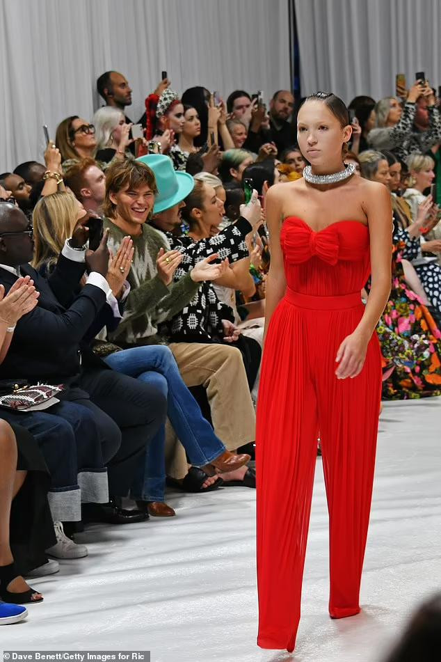 Tại tuần lễ thời trang London (Anh) mới đây, cô gái 19 tuổi mặc bộ jumpsuit màu đỏ, dáng quây ngực mở màn show Xuân-Hè 2022 của Richard Quinn. Đặc biệt, hàng lông mày của nàng mẫu được tẩy trắng tạo ấn tượng lạnh lùng kiêu sa.