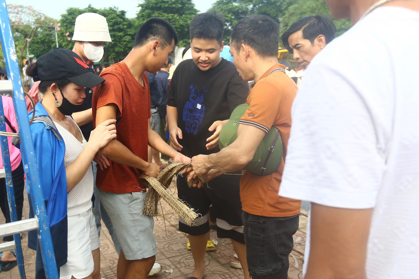 Một người dân may mắn cướp được một mảnh chiếu đem chia cho nhiều người khác.