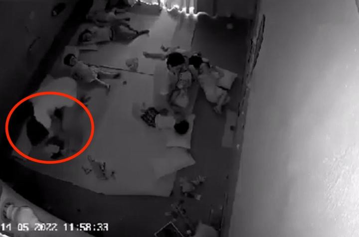 Giáo viên dùng túi nilon trùm lên đầu trẻ. (Ảnh cắt từ clip)