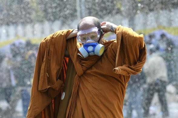 Một nhà sư đeo mặt nạ phòng độc giữa cuộc đụng độ