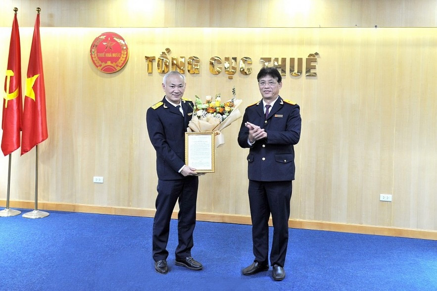 Phó Tổng cục trưởng Tổng cục Thuế Đặng Ngọc Minh trao quyết định, tặng hoa chúc mừng tân Phó trưởng Ban Cải cách và hiện đại hóa Nguyễn Hữu Hùng. Ảnh: TCT-BTC.