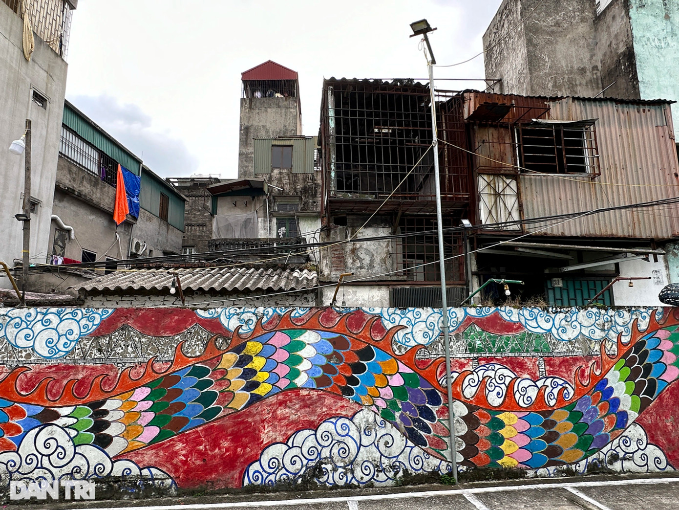 Mảng vẽ tranh tường của tác phẩm "Rồng của dòng sông" không còn đúng như ý tưởng ban đầu dùng bu gà làm lồng đèn chiếu sáng bức tranh.