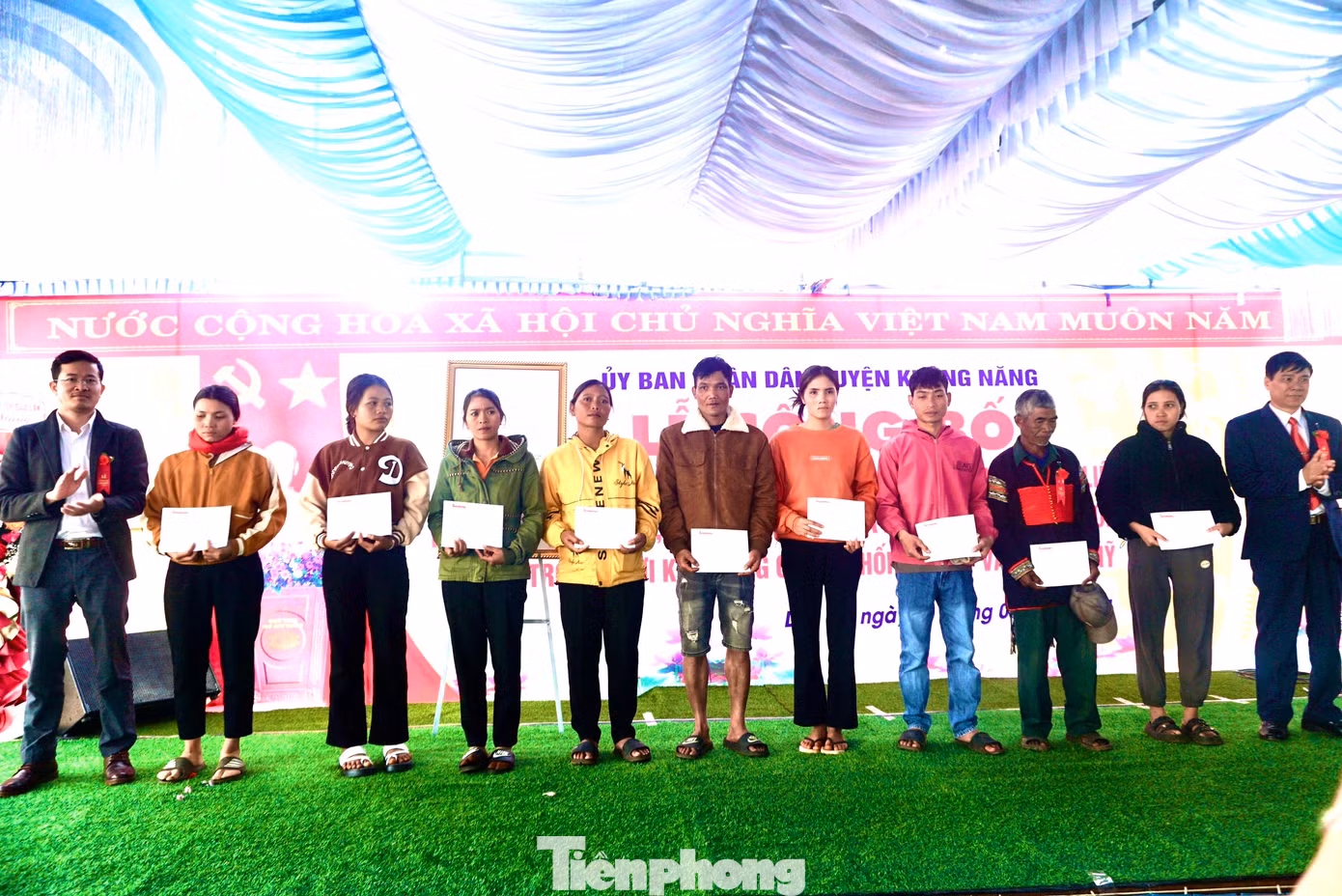 Nhà báo Nguyễn Văn Tuấn (bìa trái), phụ trách VPĐD Tiền Phong khu vực Tây Nguyên cùng đại diện lãnh đạo huyện trao quà cho các hộ nghèo của xã Dliê Ya.