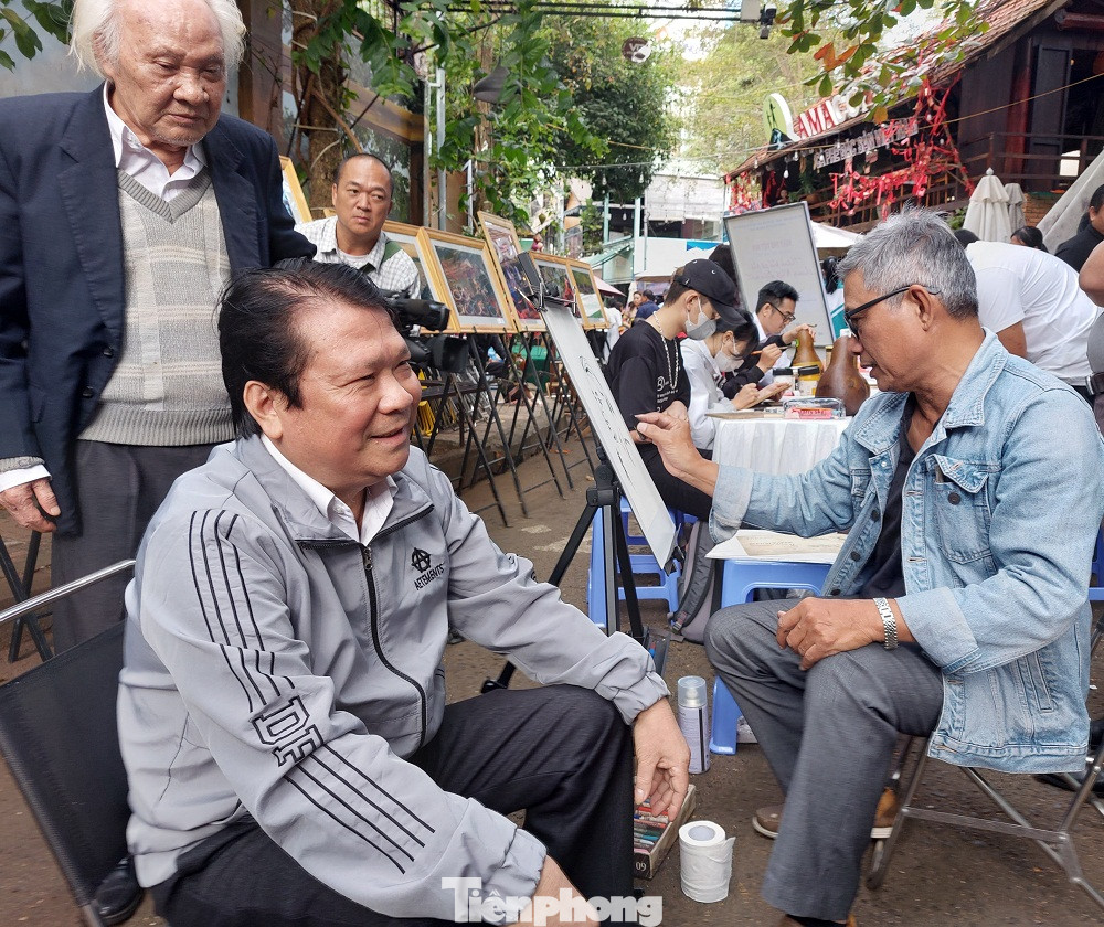Họa sĩ Trần Thanh Long ký họa chân dung.