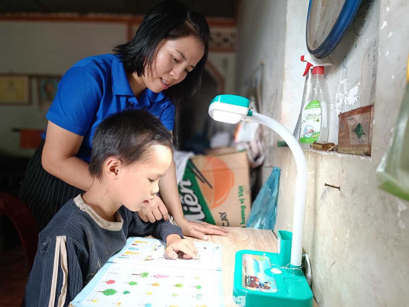 Học sinh nghèo được tặng bộ bàn học và được giáo viên đến nhà ôn tập bài