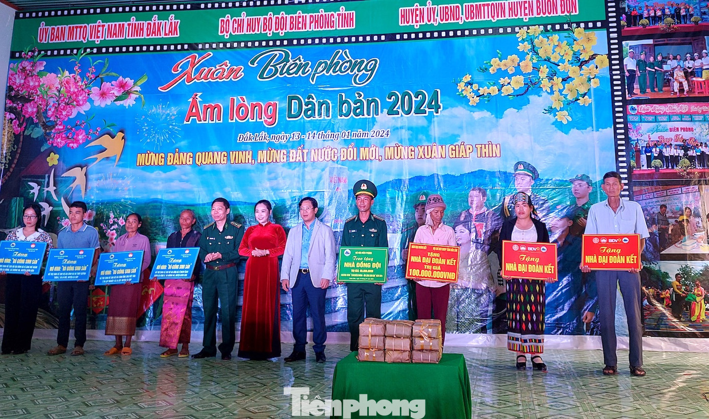 Người dân nhận bảng tượng trưng nhà và mô hình sinh kế.