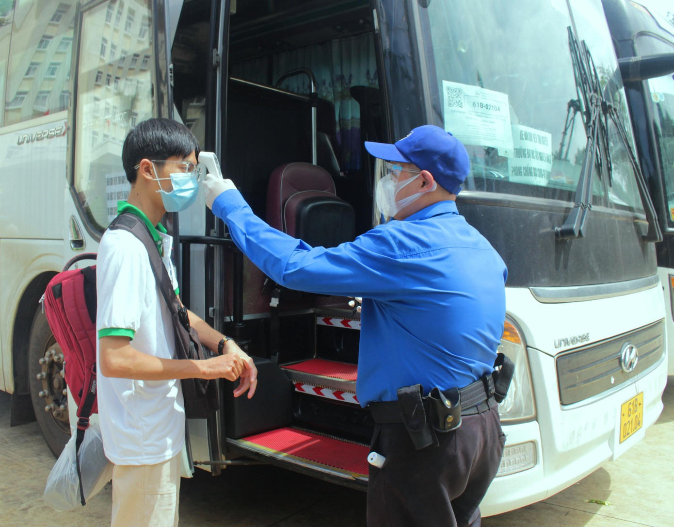 Trước khi lên xe các sinh viên được đo thân nhiệt và sát khuẩn Trước khi lên xe các sinh viên được đo thân nhiệt và sát khuẩn