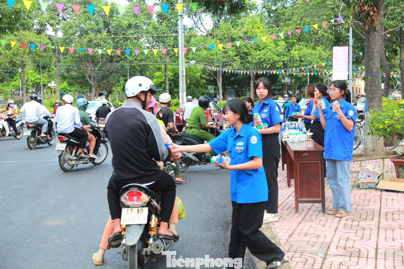 Các tình nguyện viên phát nước, sữa cho thí sinh và người nhà thí sinh; Phối hợp với cảnh sát giao thông phân luồng, điều tiết giao thông đảm bảo an toàn tại các cổng trường.