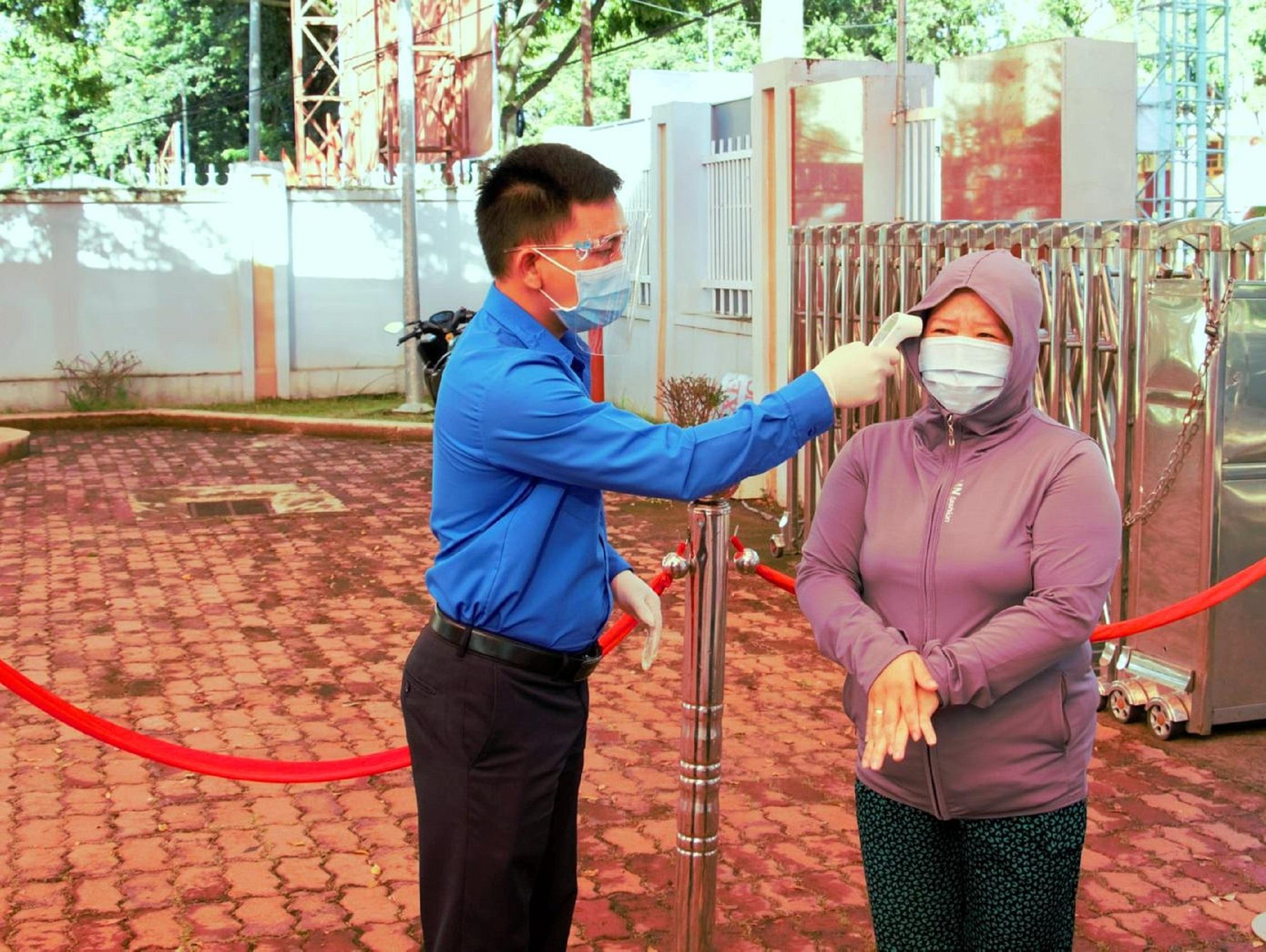 Đoàn thanh niên đo thân nhiệt cho người dân khi đến mua hàng