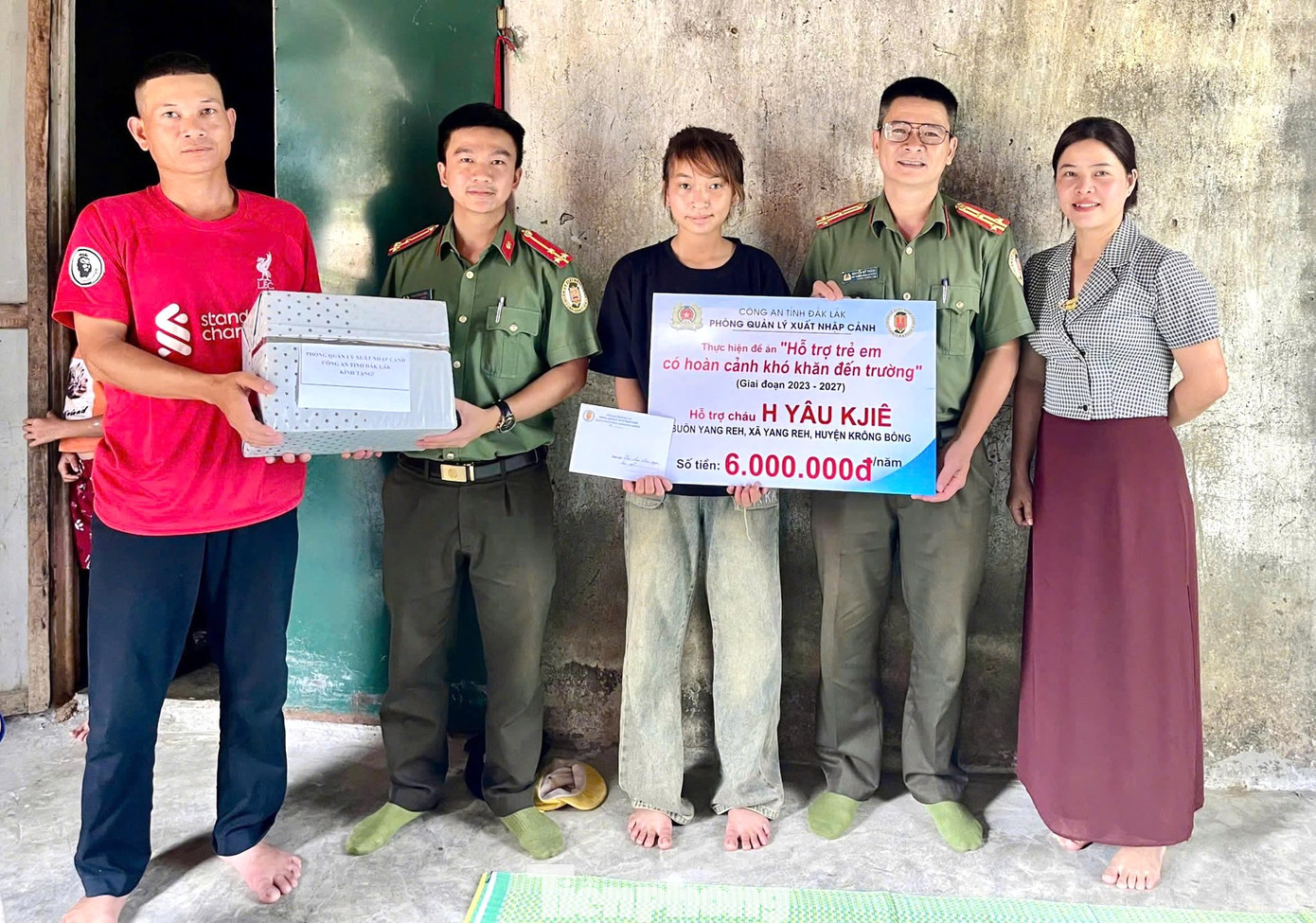 Đại diện phòng Quản lý Xuất nhập cảnh đã trao tặng phần hỗ trợ 6 triệu đồng/năm cho em H&apos;Yâu Kjiê