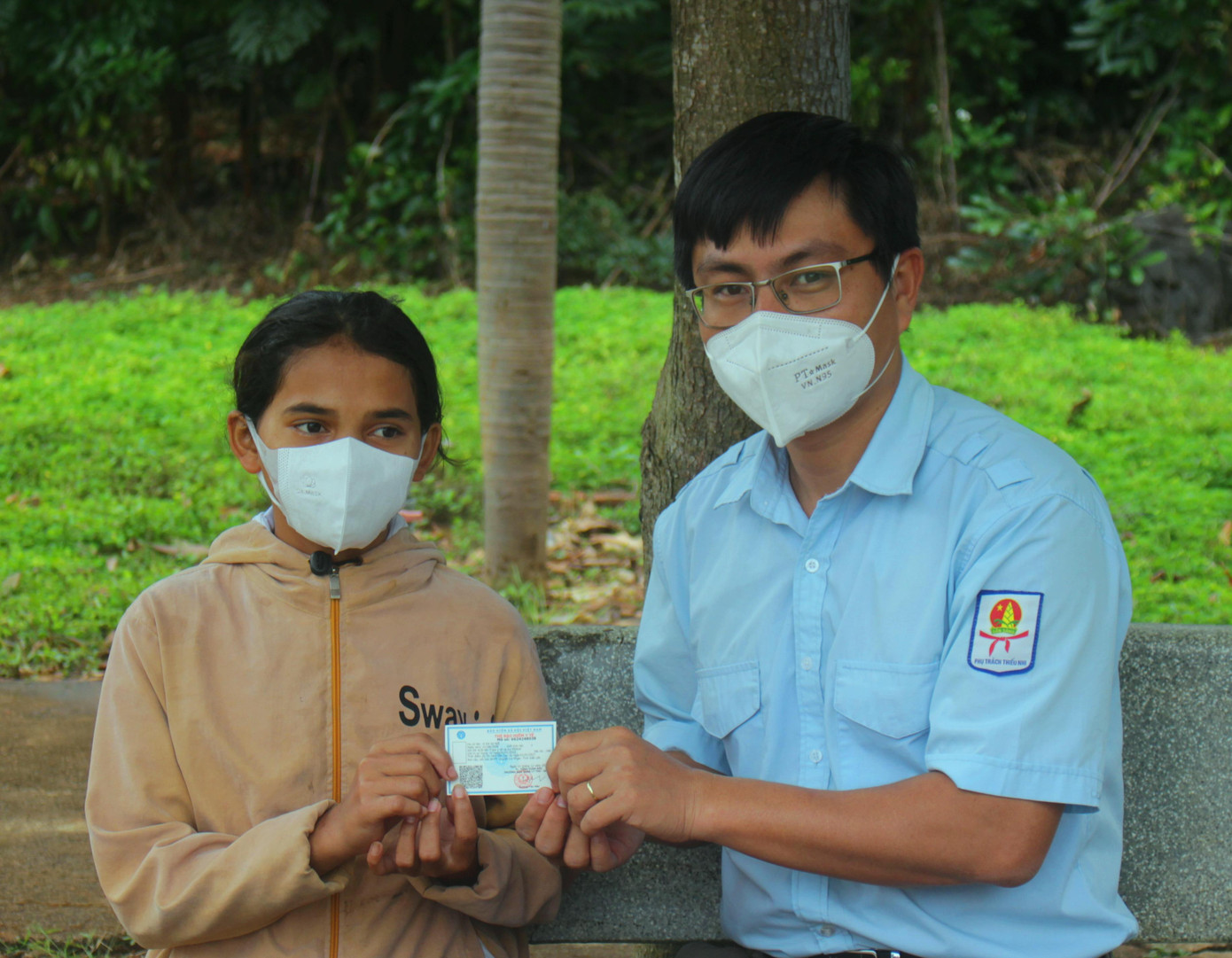 Thầy Mai Văn Chuyền trao tặng thẻ bảo hiểm y tế cho học sinh khó khăn
