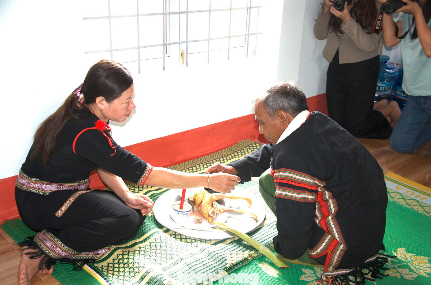 Thầy cúng Y Chôch Niê thực hiện nghi thức đeo vòng đồng cho chủ nhà.