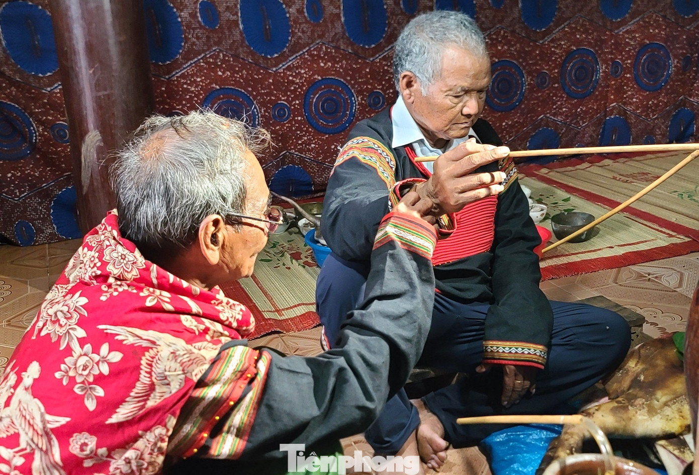 Sau đó, chủ lễ ngồi xuống bên ché rượu, đeo vòng đồng vào cổ tay.