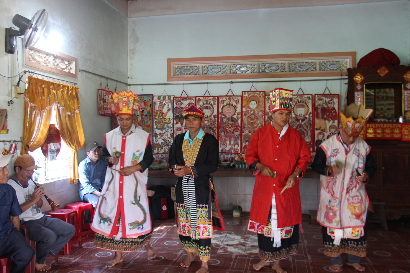 Người làm lễ cấp sắc và thầy cúng đang đi quanh nhà khấn vái tổ tiên. Ông Triệu Sinh Nghĩa (SN 1971, xã Cư Suê, huyện Cư M’gar, Đắk Lắk) mặc áo đỏ là người được làm lễ cấp sắc.
