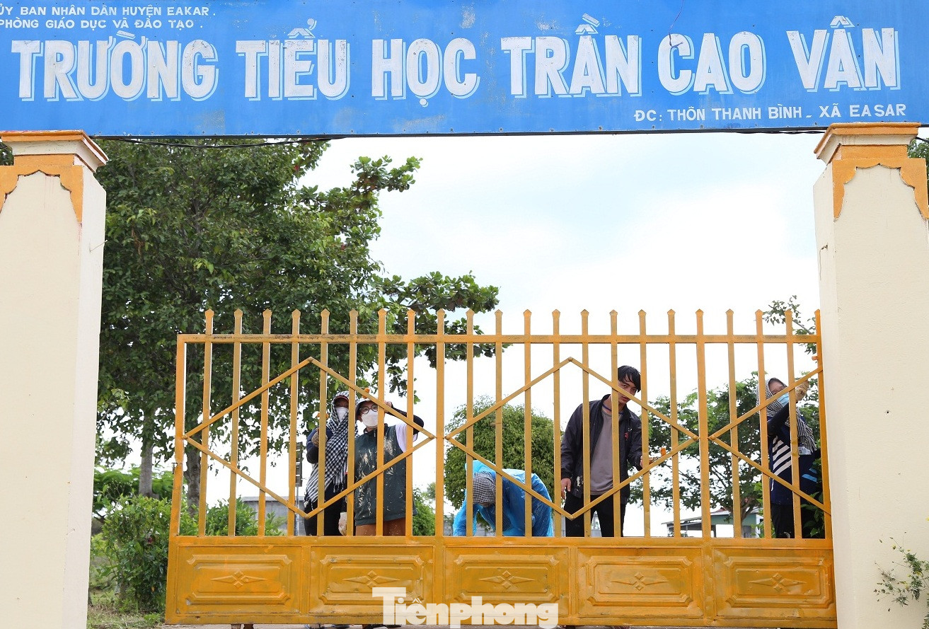 Các tình nguyện viên sơn mới cổng trường