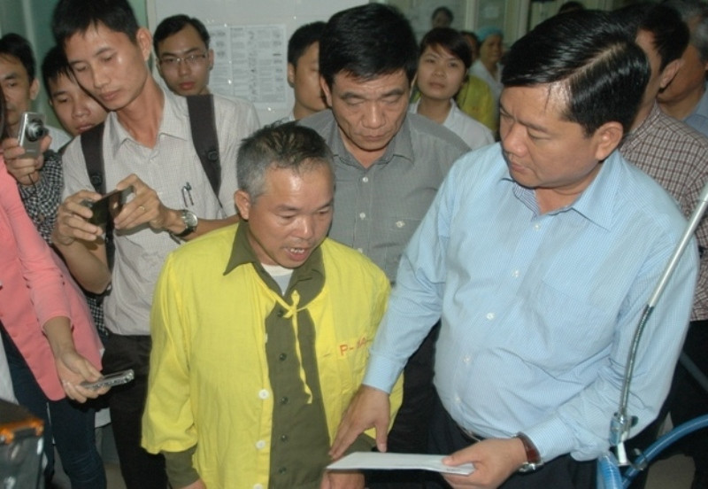 Bộ trưởng Đinh La Thăng trao số tiền hỗ trợ từ Ủy ban An toàn Giao thông Quốc gia cho ông của em Bảo, chia sẻ với gia đình trong việc chữa trị cho em