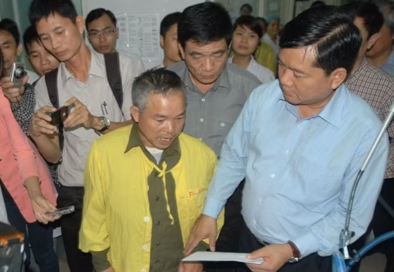 Bộ trưởng Đinh La Thăng trao số tiền hỗ trợ từ Ủy ban An toàn Giao thông Quốc gia cho ông của em Bảo, chia sẻ với gia đình trong việc chữa trị cho em