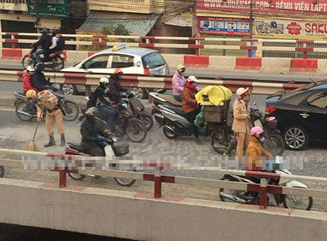 Hình ảnh hai chiến sĩ CSGT quét sỏi trên đường 