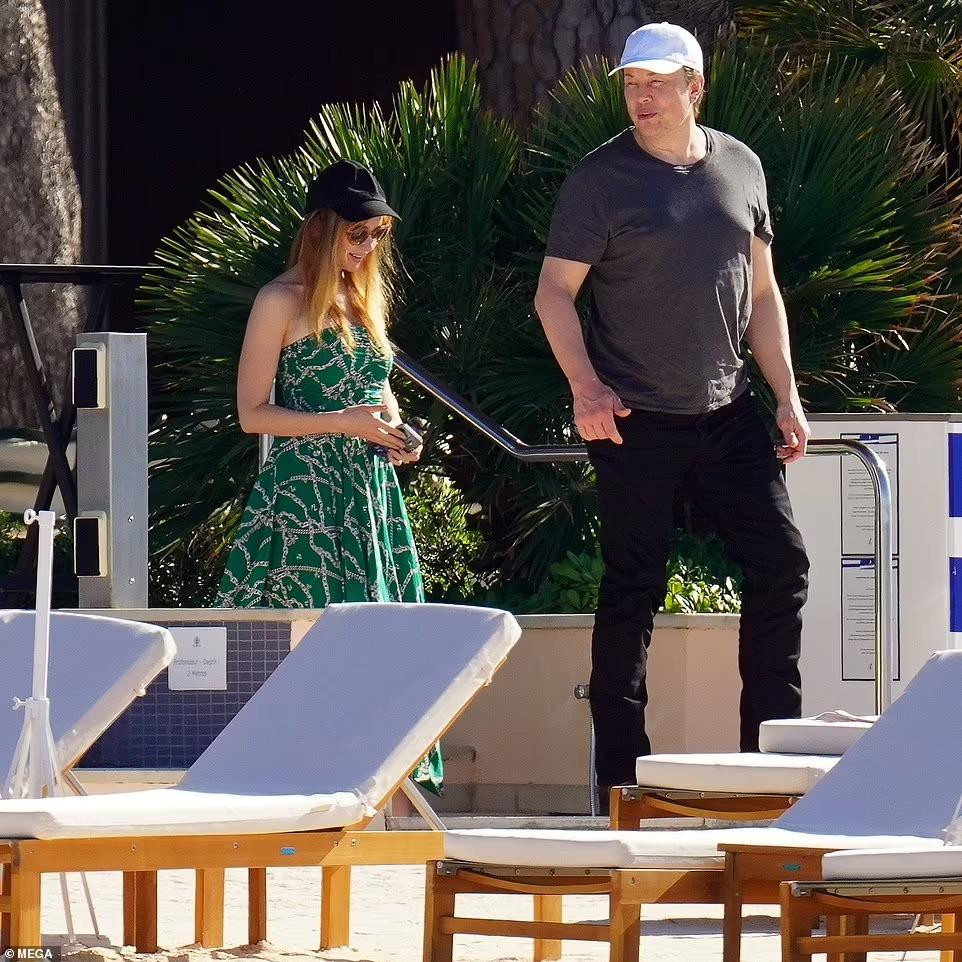 Natasha mặc váy maxi hở vai màu xanh lá, họa tiết xích bạc, có giá 698 USD (hơn 16 triệu đồng), phối với mũ lưỡi trai đen, túi xách và sandal màu bạc. Trong khi đó, tỷ phú giàu nhất thế giới giản dị với áo phông xám, quần jean đen và mũ lưỡi trai trắng.