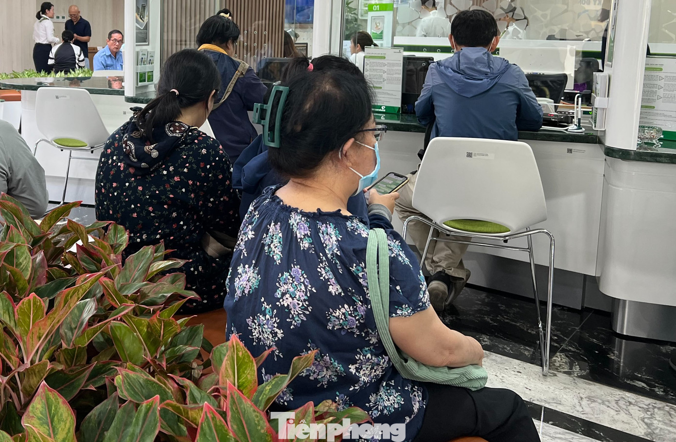 Khách ngồi tại một ngân hàng chờ đợi xác thực sinh trắc học. Khách ngồi tại một ngân hàng chờ đợi xác thực sinh trắc học.