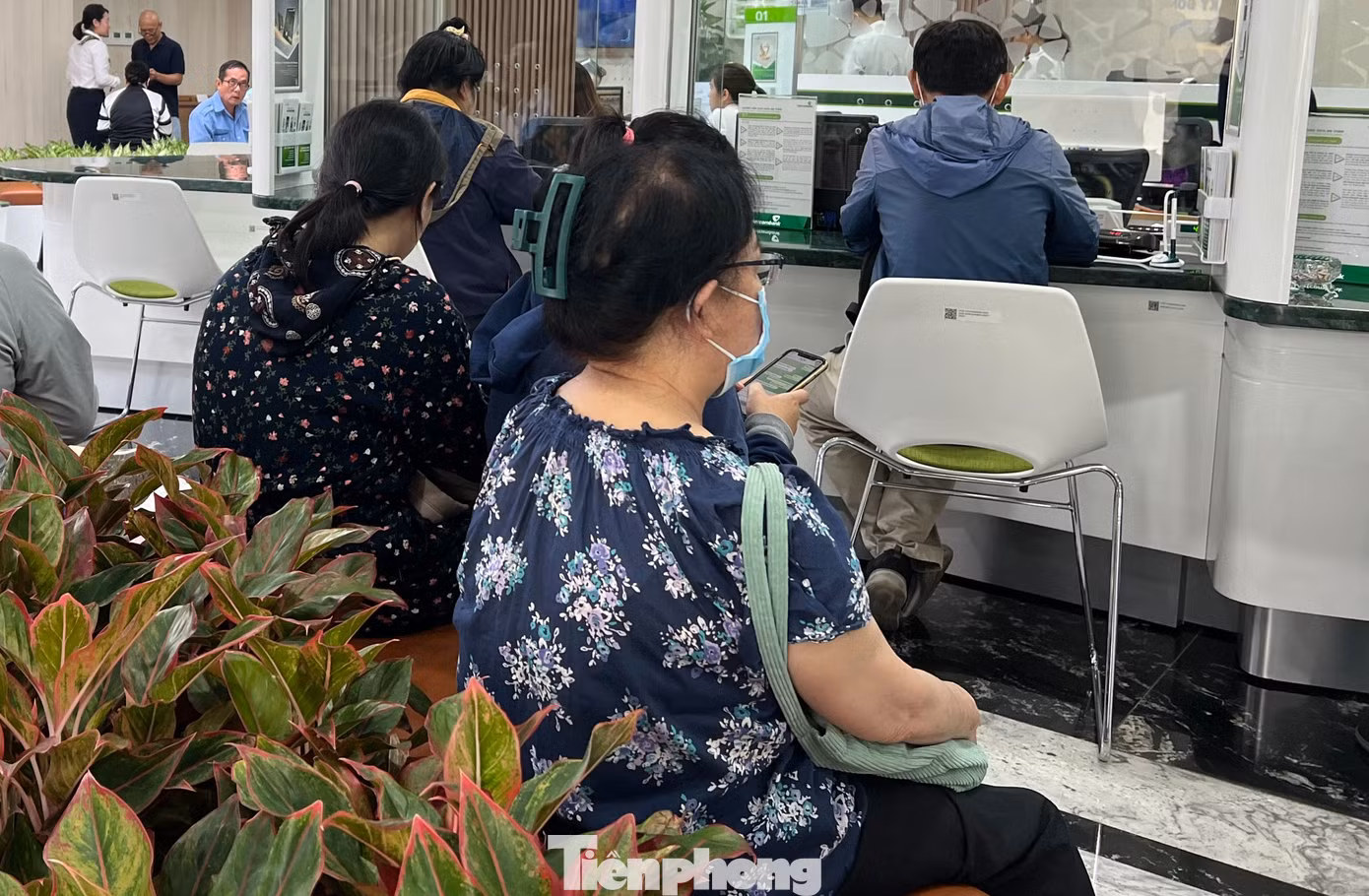 Khách ngồi tại một ngân hàng chờ đợi xác thực sinh trắc học. Khách ngồi tại một ngân hàng chờ đợi xác thực sinh trắc học.