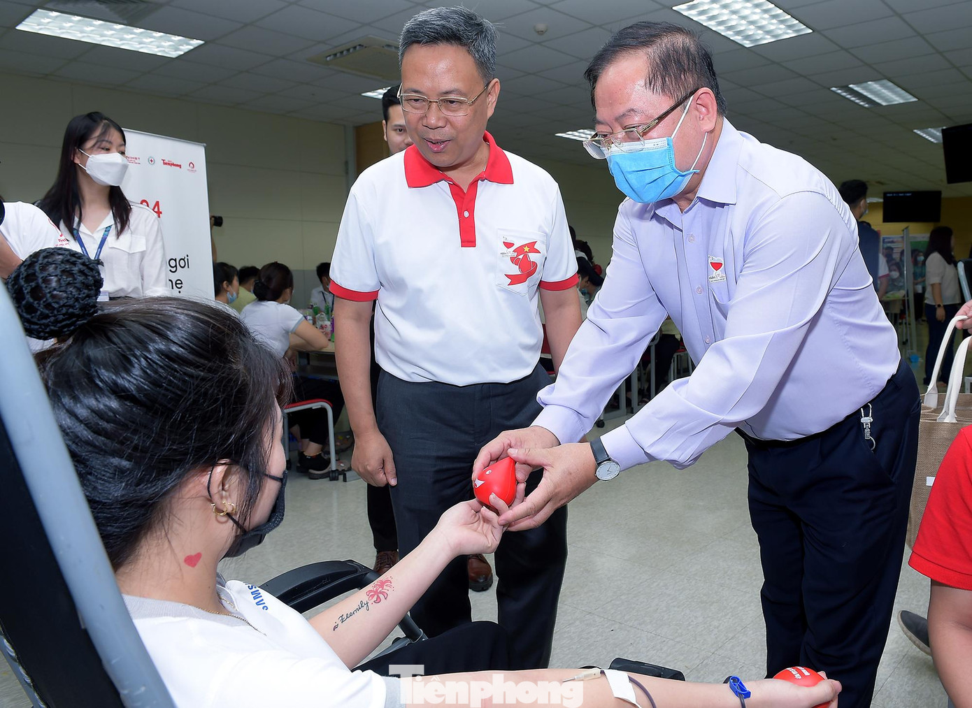 Nhà báo Lê Xuân Sơn và PGS, TS. Nguyễn Hà Thanh thăm hỏi, tặng quà lưu niệm người tham gia hiến máu tại chương trình. Ảnh: Xuân Tùng