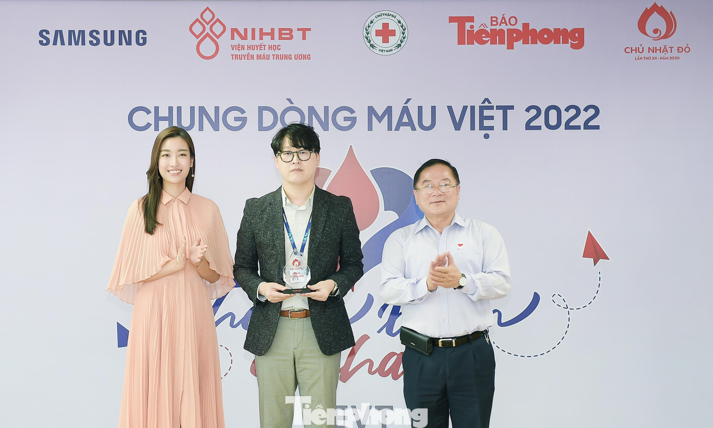 Nhà báo Lê Xuân Sơn và Hoa hậu Việt Nam Đỗ Mỹ Linh tặng kỷ niệm chương Chủ nhật Đỏ tới ông Lee Seung Ho. Ảnh: Xuân Tùng