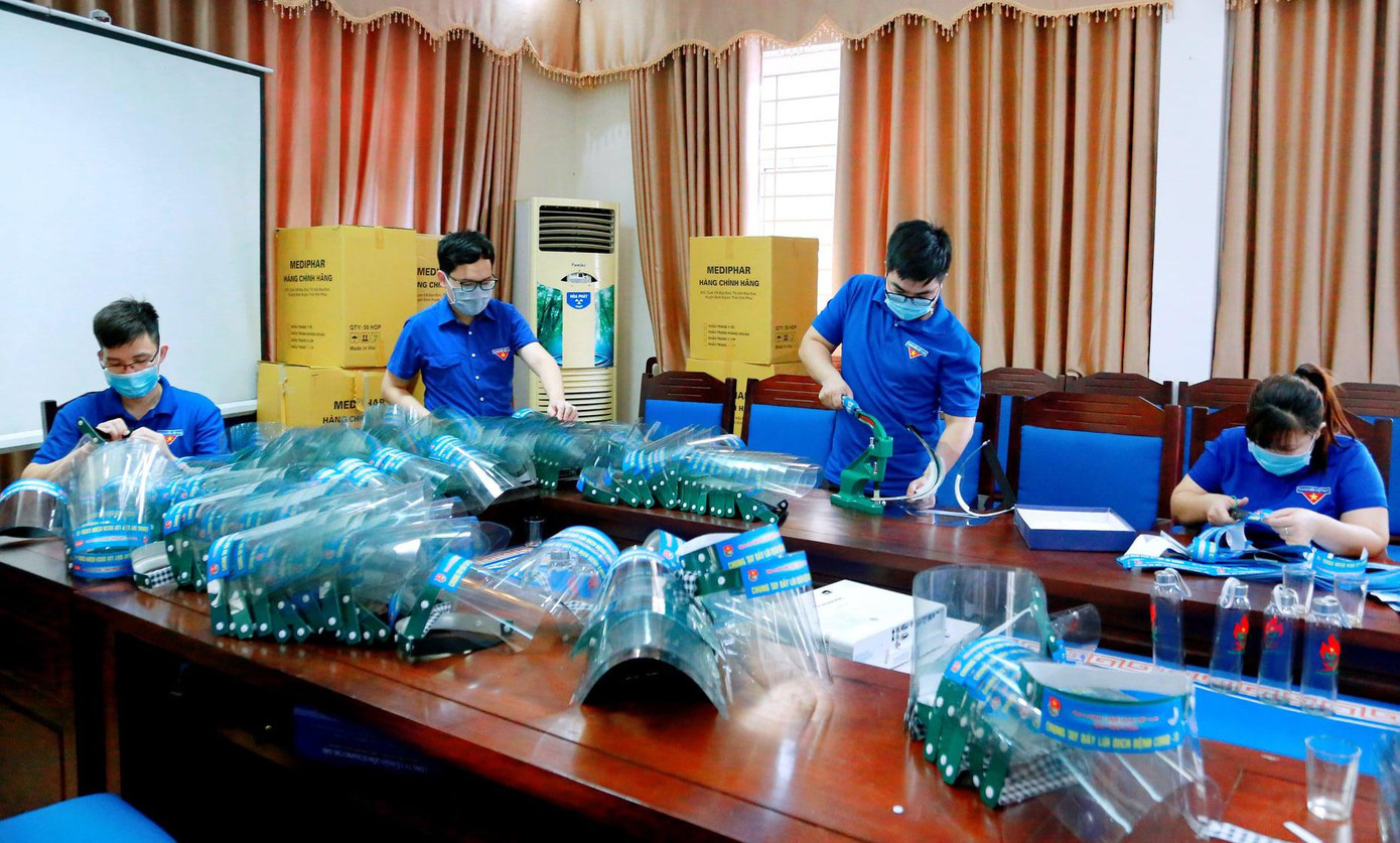 Đoàn viên thanh niên làm mũ chống giọt bắn góp phần phòng chống dịch COVID-19. Ảnh: TĐVP