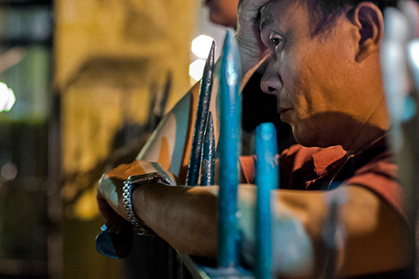 Một người đàn ông với vẻ mặt thẫn thờ đang dựa vào hàng rào trước cửa nhà của Đại Tướng