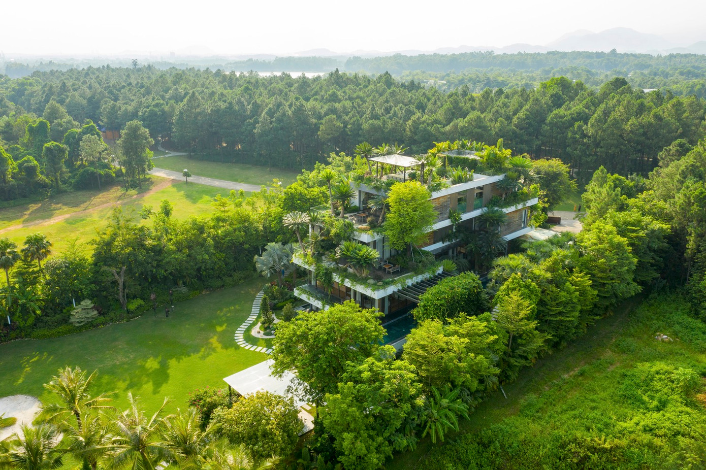 Không gian của biệt thự bao gồm những khu vườn xanh mát, được quy hoạch tổng thể kết hợp với bể bơi, khu vui chơi, địa hình cao thấp tạo nên kiến trúc xanh hài hòa.