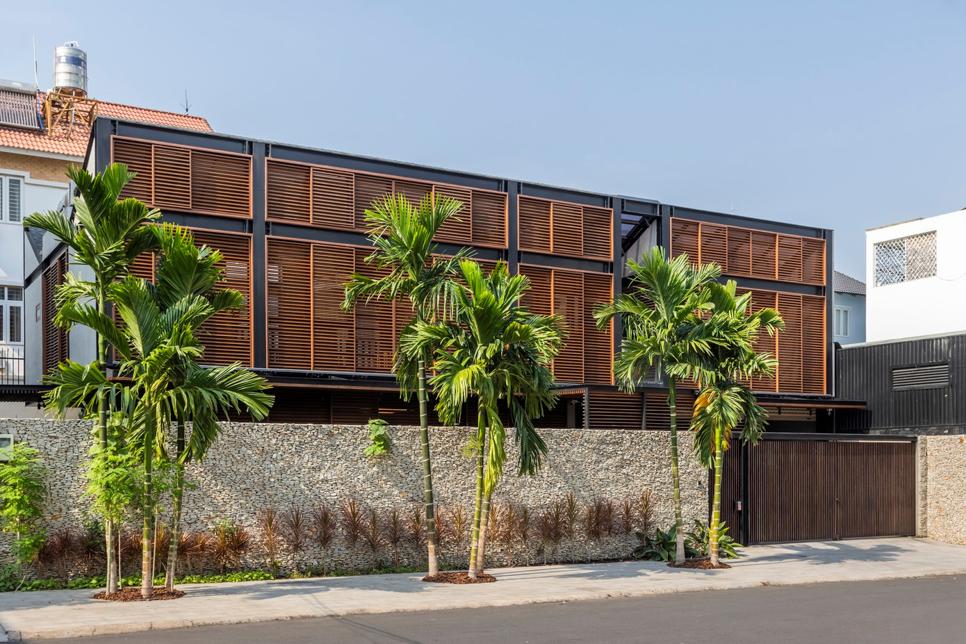 Để đáp ứng nhu cầu của gia chủ, các kiến trúc sư đã triển khai giải pháp thông minh mang tên “Mặt tiền hai lớp”. Cấu trúc này bao gồm hệ thống lam gỗ cách nhiệt (gỗ đã được xử lý nhiệt để tăng độ bền) ở bên ngoài, kết hợp với hệ thống kính trượt bên trong.