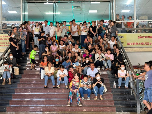 Tiểu thương, người làm công ở chợ An Đông tập trung ở lối đi vào chợ sáng 19/6. Tiểu thương, người làm công ở chợ An Đông tập trung ở lối đi vào chợ sáng 19/6.