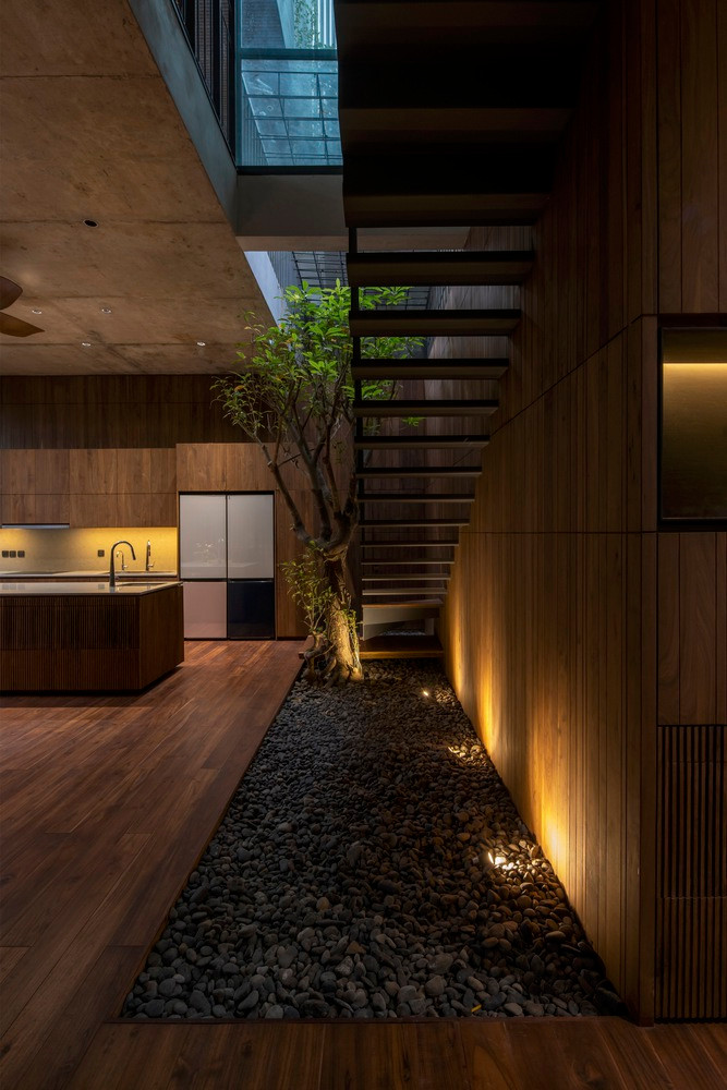 Ngôi nhà sử dụng chủ yếu các nguyên vật liệu thô như (đá xanh, đá ong xám, gỗ, cây cối…), nhằm mang lại sự gần gũi, quen thuộc với cuộc sống trước đây của gia chủ, và cho phép dự án hòa nhập với bối cảnh xây dựng xung quanh.