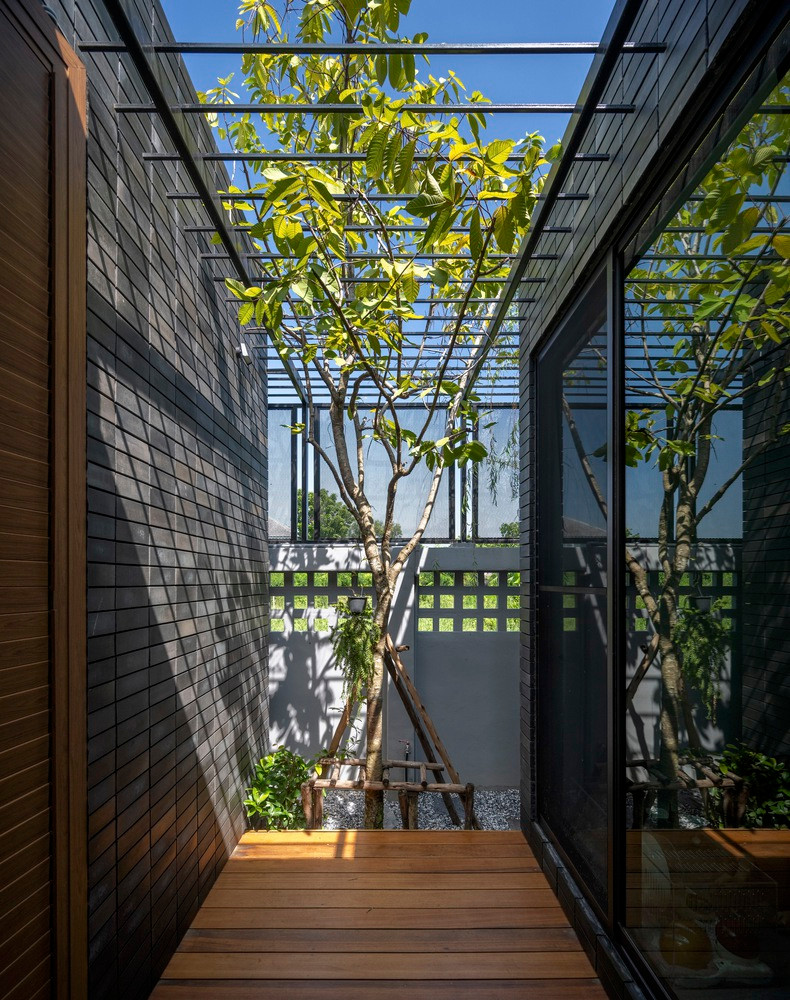 Bức tường màu xám đen giúp giảm bức xạ mặt trời vào một số khu vực của ngôi nhà lúc ban ngày.