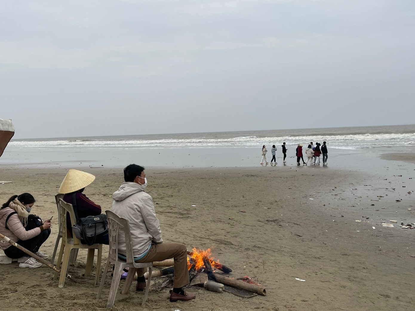 Những người thợ ảnh tại bãi biển Sầm đốt lửa sưởi ấm, chờ đợi những vị khách đến từ khắp nơi xa gần thuê chụp ảnh đầu năm.