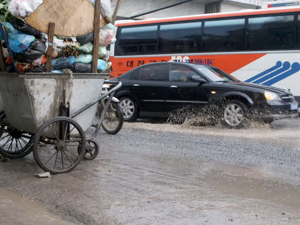 Vị trí xảy ra vụ tai nạn khiến 3 nạn nhân tử vong (25-8) vừa ổ gà ổ voi lại cõng thêm hàng chục xe rác. Ảnh: Minh Đức