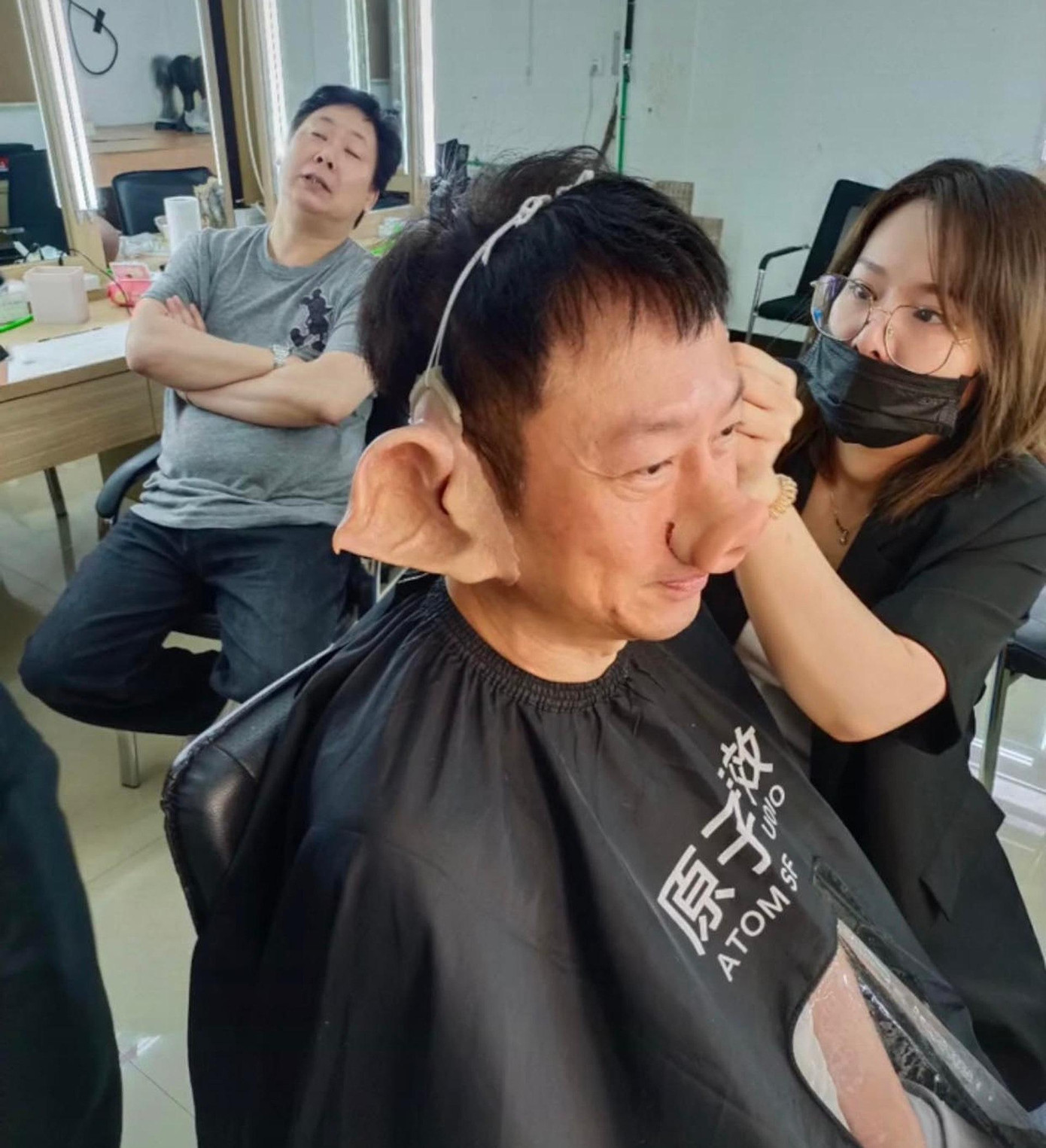 Công đoạn kỳ công nhất là gắn phần tai và mũi giả làm bằng cao su. Tổ hóa trang sử dụng keo cố định vị trí rồi sấy nóng. Ảnh: HK01. Công đoạn kỳ công nhất là gắn phần tai và mũi giả làm bằng cao su. Tổ hóa trang sử dụng keo cố định vị trí rồi sấy nóng. Ảnh: HK01.