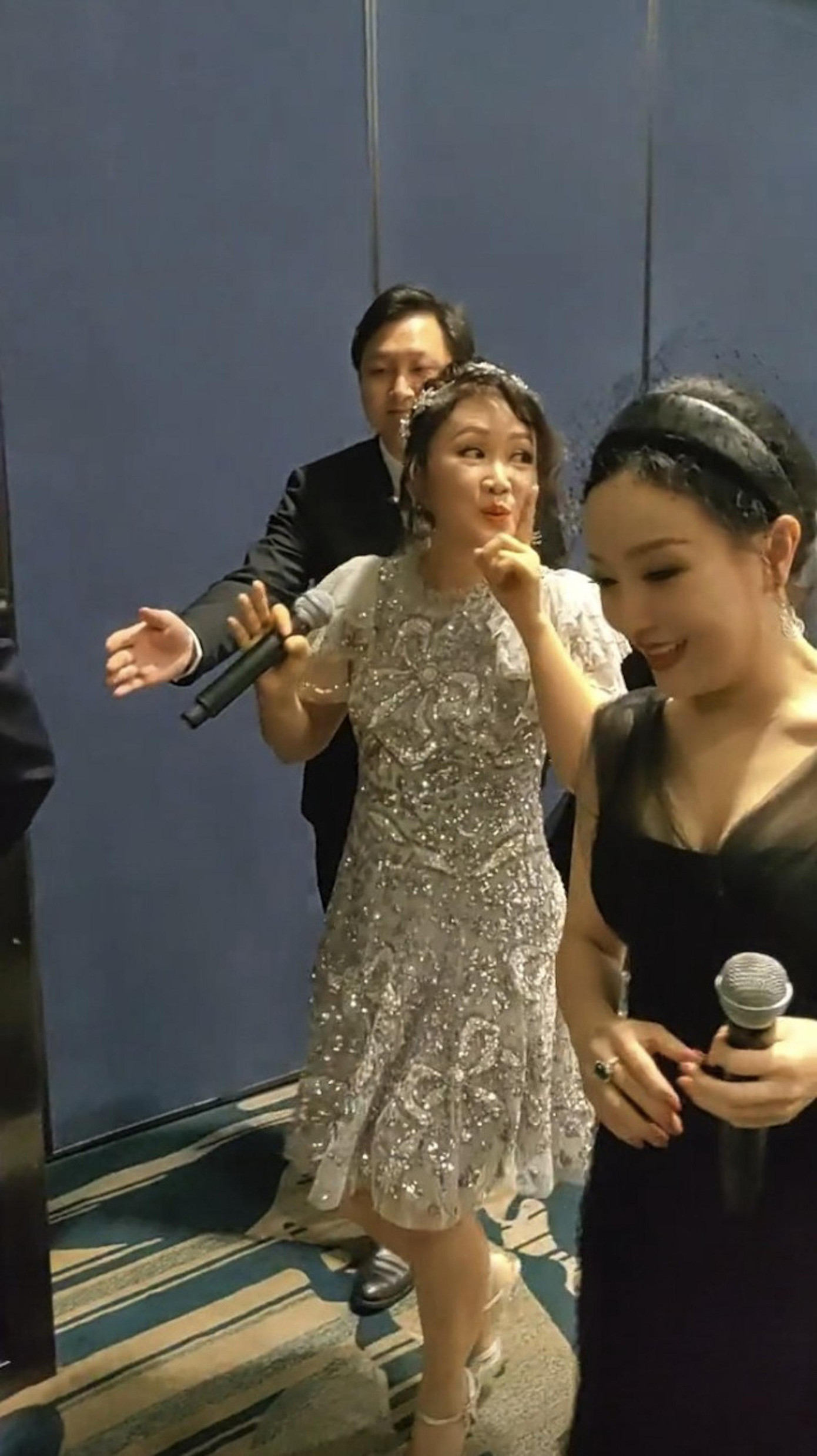 Lương Tiểu Băng mặc đầm lấp lánh và được vệ sĩ hộ tống. Ảnh: HK01. Lương Tiểu Băng mặc đầm lấp lánh và được vệ sĩ hộ tống. Ảnh: HK01.