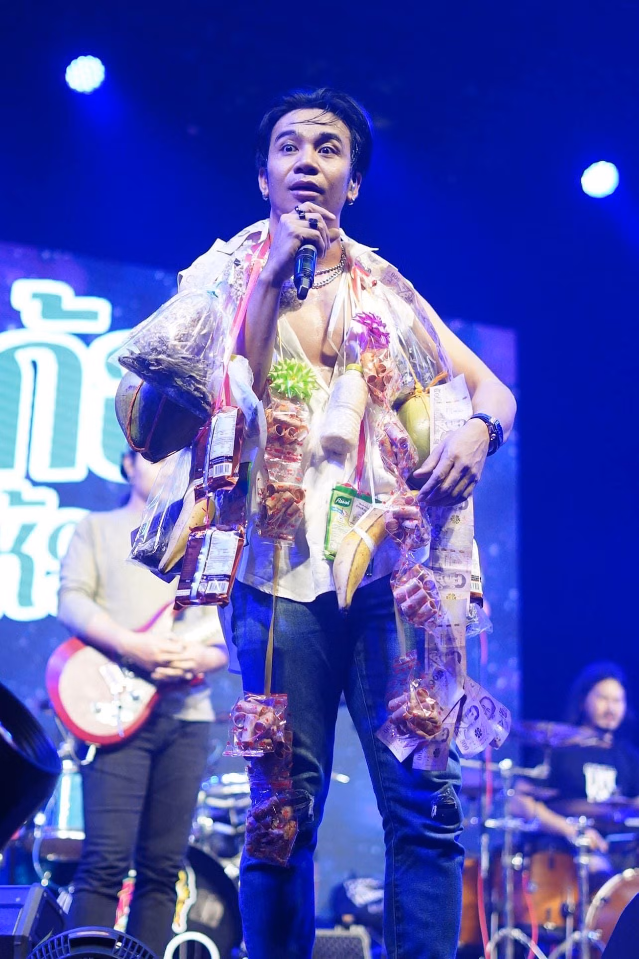 Kong Huayrai - nam ca sĩ Thái Lan nhận được sự chú ý lớn của cư dân mạng với loạt hình sân khấu độc, lạ, hài hước. Mỗi lần đi diễn, Kong Huayrai thường được người hâm mộ tặng những vật phẩm như cây cảnh, đồ ăn… Tất cả quà ca sĩ đều treo lên cổ và trình diễn.